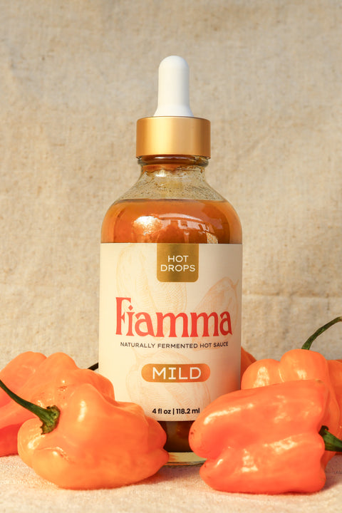 Fiamma hot sauce bottle with peppers on a textured background